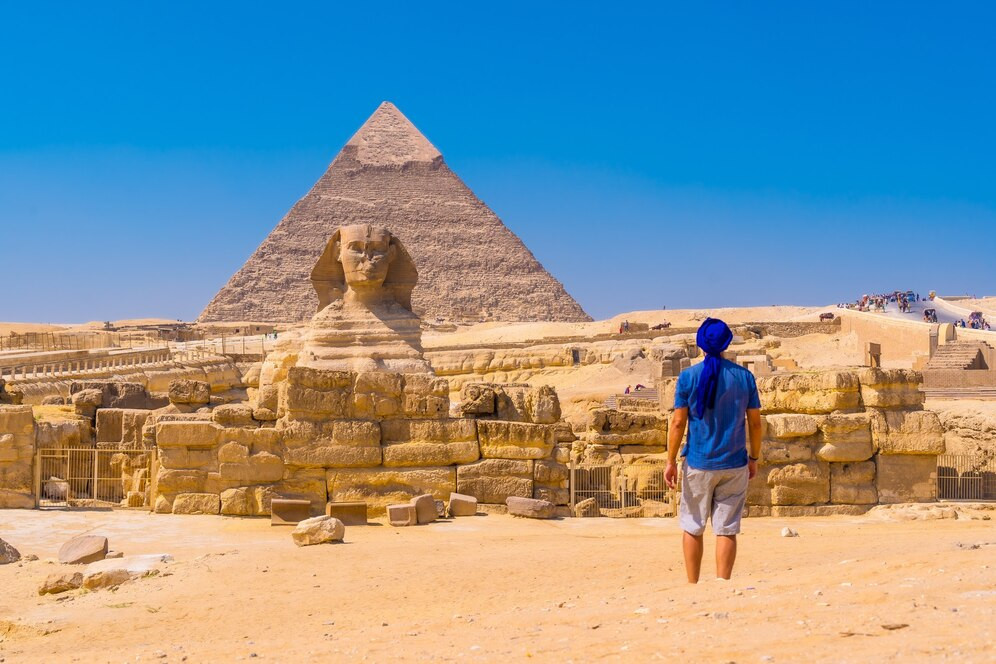 young-man-walking-towards-the-great-sphinx-of-giza-a_181624-51674