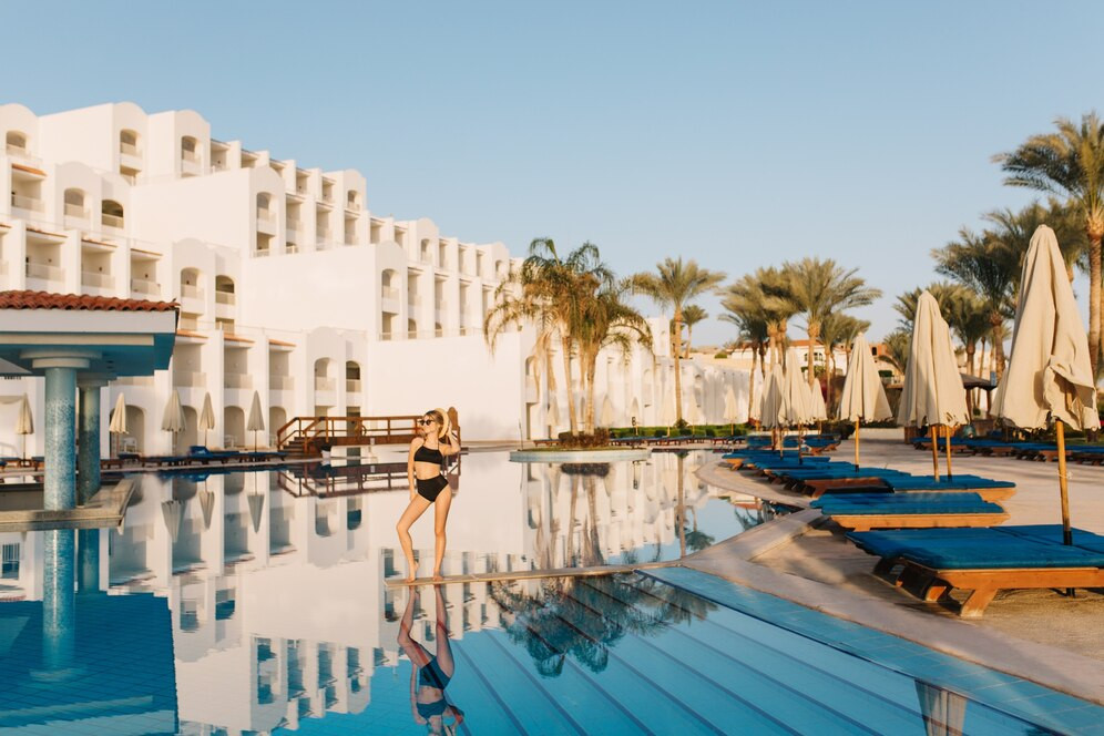 luxury-white-hotel-egypt-eastern-style-resort-with-nice-big-pool-pretty-girl-model-wearing-black-swimsuit-posing-in-the-middle-of-the-pool-vacation-holiday-summertime_197531-3135